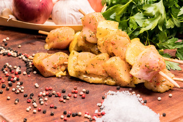 raw chicken skewers marinated with lemon on a wooden board