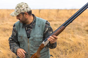 Hunter with a hat and a gun in search of prey in the steppe	