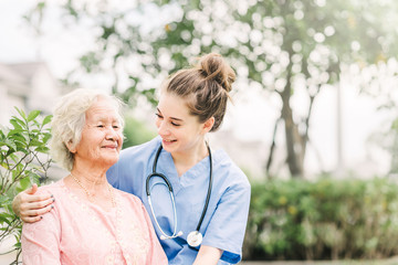 Caregiver with Asian elderly woman outdoor