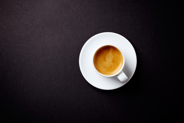 Cup of coffee on black background. Top view. Copy space.