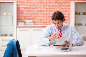 Young handsome employee working in the office 