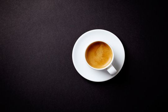 Fototapeta Cup of coffee on black background. Top view. Copy space.