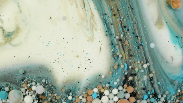 Colorful paint in bubbles organically moves in the liquid
