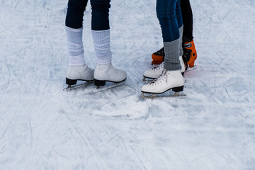 Legs of a three women with ice skating shoes on ice