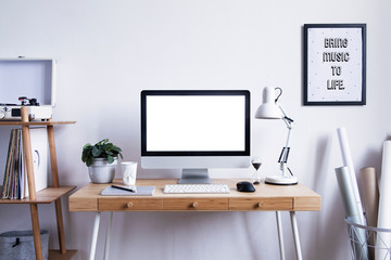 Scandinavian interior of home desk with mock up computer screen, photo frame, office accessories, projects and gramophone. Minimalistic space for work, hobby and listen music. 