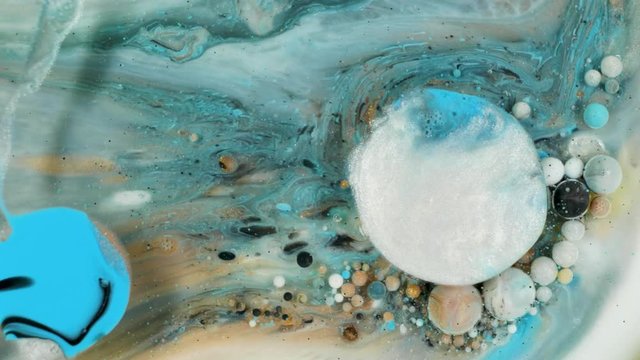 Colorful paint in bubbles organically moves in the liquid