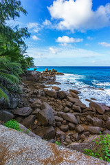 Fototapeta na wymiar Granite rocks on a rough coast of the ocean, anse bazarca, seychelles 2