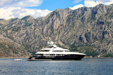 Montenegro.  Large white yacht sails in the Bay of Kotor near the town of Herceg Novi in Montenegro