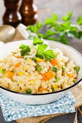 Bulgur wheat boiled with carrot, green peas and corn, healthy vegan diet