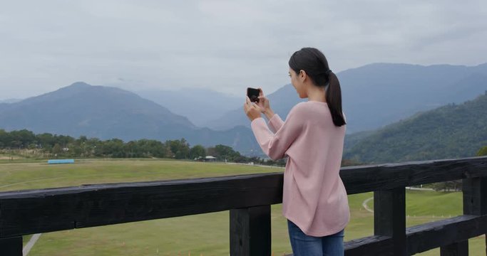 Woman take photo on cellphone in the luye highland at Taitung