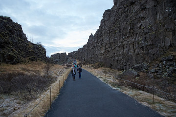 Thingvellir, Iceland - July 19, 2017: Tourists walk through the Almannagja fault line in the mid-atlantic ridge north american plate in Thingvellir National Park. Iceland