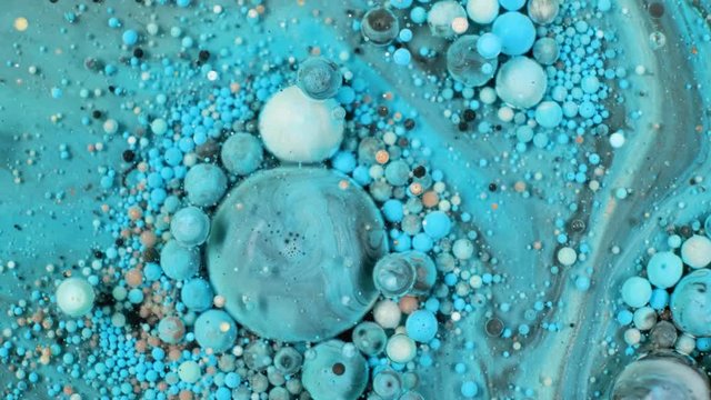 Colorful paint in bubbles organically moves in the liquid