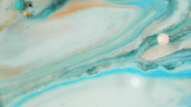 Colorful paint with silver particles organically moves in the liquid