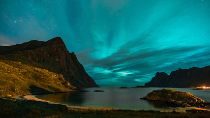 Aurora over sandy beach haukland, Kvalvika and Skagsanden with stones in Norway, Lofoten islands....