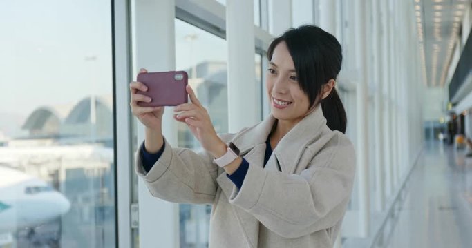 Businesswoman use of mobile phone for take photo in the airport