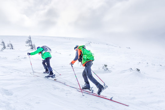 Two ski sportsmen going up to the  summit in snowy mountains. Skitouring sport concept.