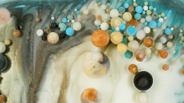 Colorful paint in bubbles organically moves in the liquid