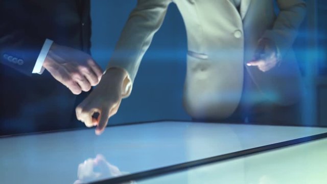 The woman and a man working with a sensor screen on a hologram background