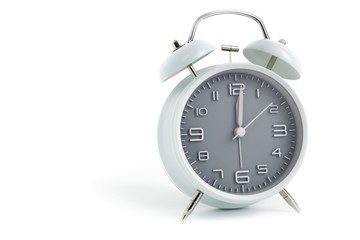 Twin bells analogue alarm clock with gray clock face shows 1 past 12, 12.01 AM PM; concept on white background