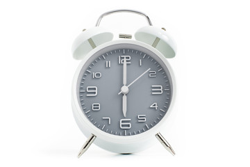 Twin bells analogue alarm clock with gray clock face shows six o’clock, 6 AM PM; concept on white background