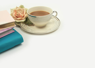 notebooks and diary with rose flower next to cup of coffee or tea on clean white office desk table. ready for adding text