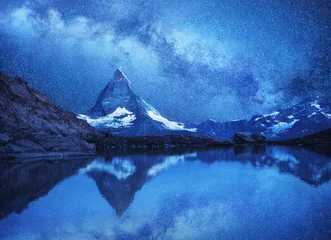 Foto op Plexiglas Matterhorn Matterhorn en reflectie op het wateroppervlak & 39 s nachts. Melkweg boven de Matterhorn, Zwitserland. Prachtig natuurlandschap in Zwitserland