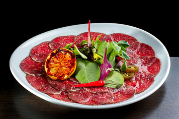 Beef carpaccio with lemon, hot red pepper and pepper jalapeno.