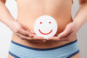 Women Health. Closeup Of Healthy Female With Beautiful Fit Slim Body Holding White Card With Happy Smiley Face. Stomach Health And Good Digestion Concepts