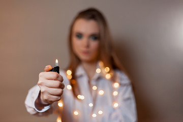 girl with a lighter on a gray background in a shirt