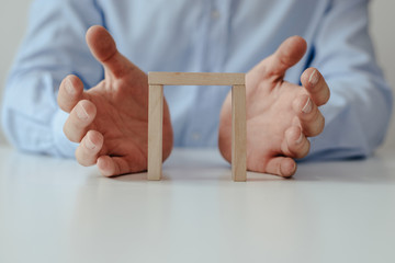 Naklejka premium Businessman in a blue shirt arranges wooden jigsaw blocks. The man arranges empty blocks one on top of the other. Different concepts to supplement with content. Business concept, HR.