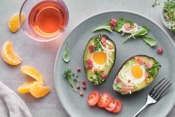Keto diet dish: Avocado boats with ham cubes, quail eggs and cheese, top lay