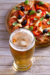 Beer and pizza on wooden plate. Ale and  snack. Vertical