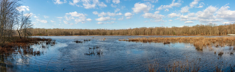 White puffy clouds float in a sunny blue sky over the rippling waters of a Virginia marsh.