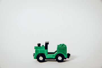 A view of a green, small toy train. Train on a white, clear background. Travel concept, trips.