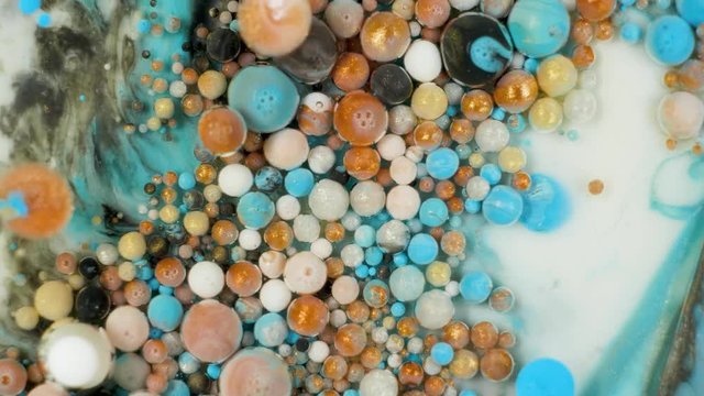 Colorful paint in bubbles organically moves in the liquid