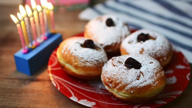 nine candles and doughnuts with sugar powder (jewish holiday Hanukkah)