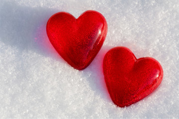 Two red hearts made of vintage glass on light background, white snow pattern, love concept, St Valentine day