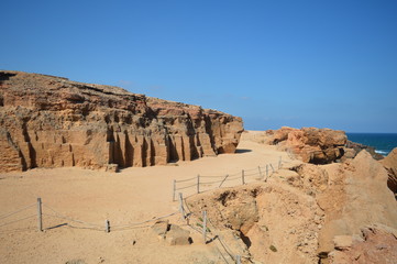 Plakat rocks and caves in front of the sea