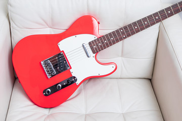 Red electric guitar on a leather sofa