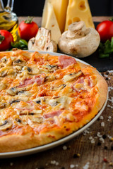 Italian pizza with ingredients on a wooden background, close up