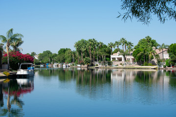 Fototapeta na wymiar Boats on a lake surround by houses and trees