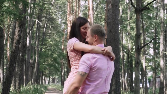 young couple in love walks in the summer park among the pines