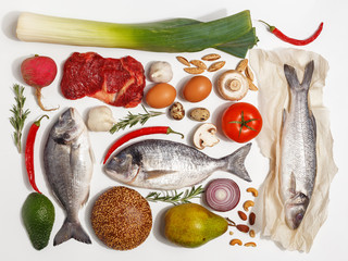Healthy food clean eating selection: fruit, vegetable, seeds, fish, meat, leaf vegetable on white background. Top view.