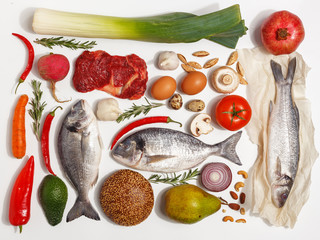 Healthy food clean eating selection: fruit, vegetable, seeds, fish, meat, leaf vegetable on white background. Top view.