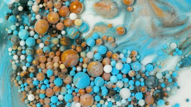 Colorful paint in bubbles organically moves in the liquid