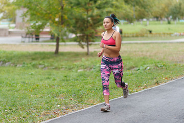 Young lady running. Woman runner running through the spring park road. Workout in a Park. Beautiful fit Girl. Fitness model outdoors. Weight Loss