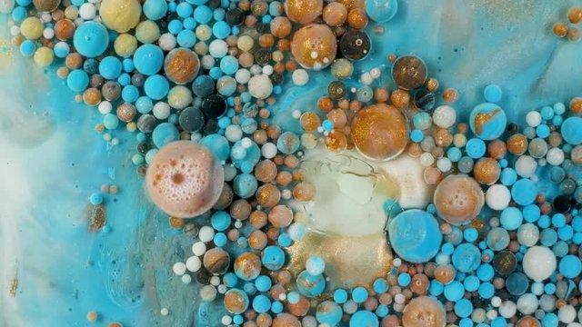 Colorful paint in bubbles organically moves in the liquid