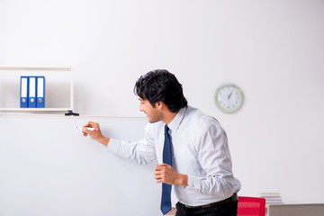 Young handsome financial speciaist in front of white board 