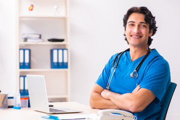 Young handsome doctor working at the clinic 