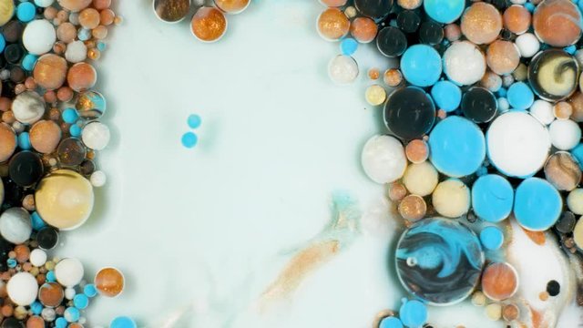 Colorful paint in bubbles organically moves in the liquid